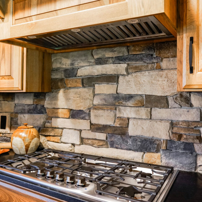 {Warm interior image of ProVia Ledgestone Brighton with Fieldstone Strathmore Manufactured Stone in kitchen}