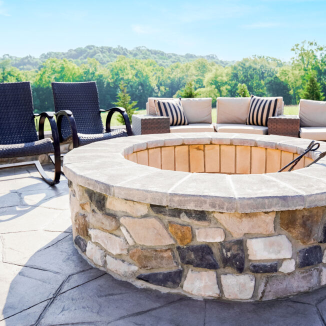 {Scenic outdoor image of a ProVia Ridge Cut Denali™ manufactured stone firepit}