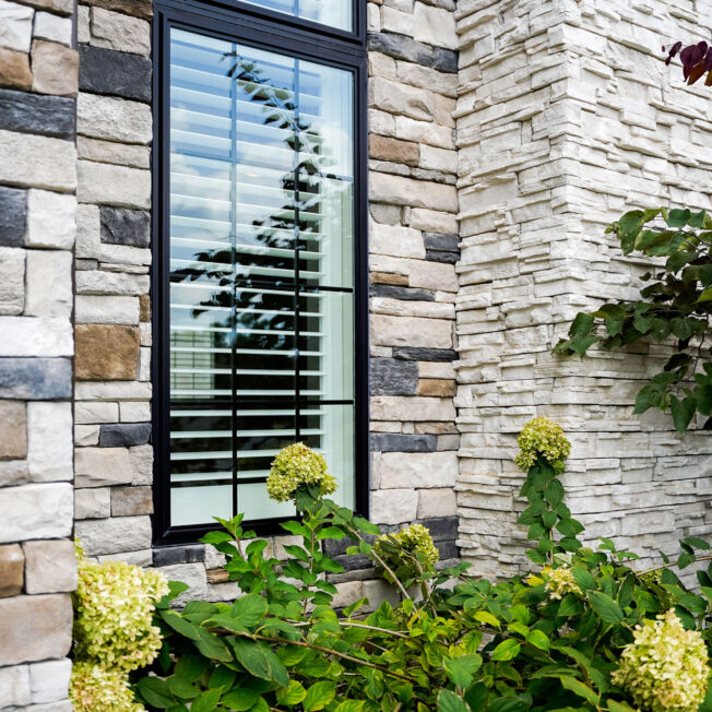 {Closeup image of ProVia Terra Cut™ Niagra & PrecisionFit™-Arctic manufactured stone on home exterior}