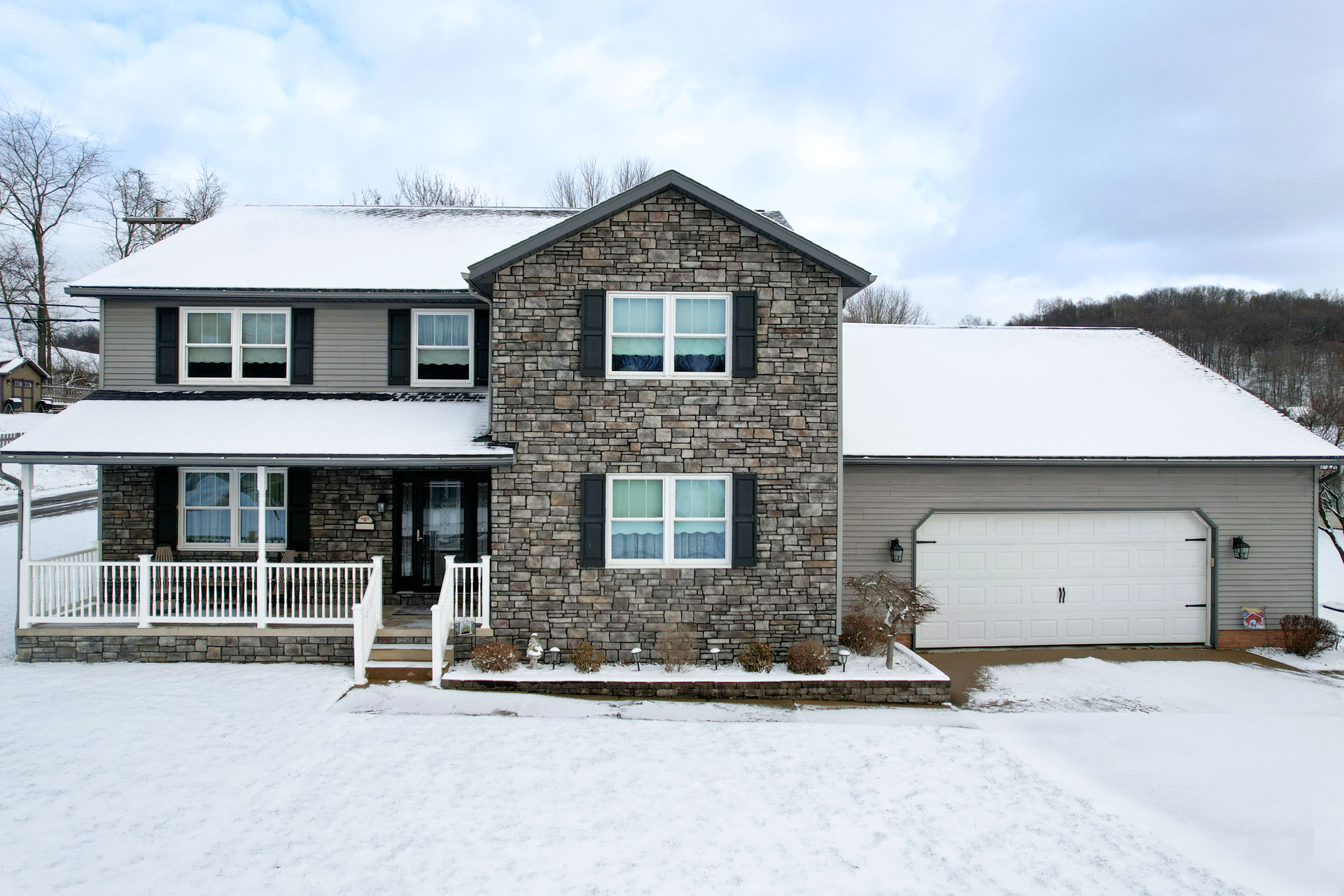 Exterior image of a snow-covered two-story home with ProVia® Aeris™ Double Hung Windows in White with Colonial Internal Grids