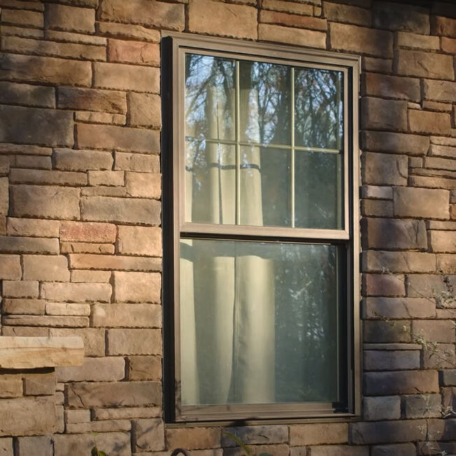 {Closeup exterior image of ProVia Aeris™ Double Hung Windows in Classic Bronze with Cottage Grids}