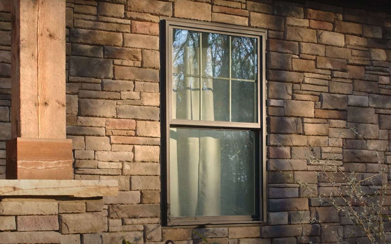 Closeup exterior image of ProVia Aeris™ Double Hung Windows in Classic Bronze with Cottage Grids