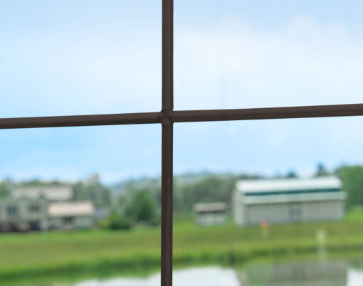 {Closeup view of pencil entry door grid option in the color Bronze}