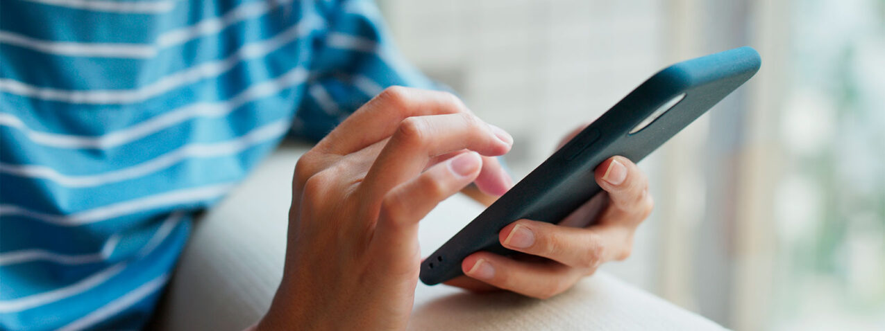 {Closeup of a person using a smart phone, which illustrates that ProVia metal roofing does not interrupt cell service}
