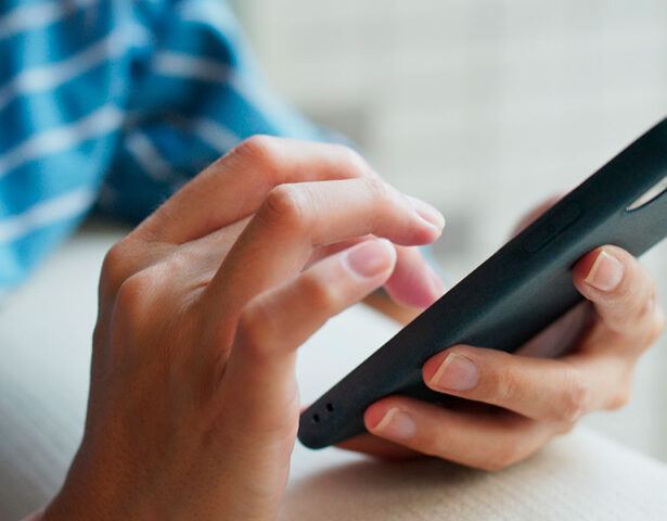 Closeup of a person using a smart phone, which illustrates that ProVia metal roofing does not interrupt cell service