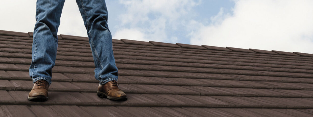 {Closeup of a contractor standing on a ProVia metal roof}