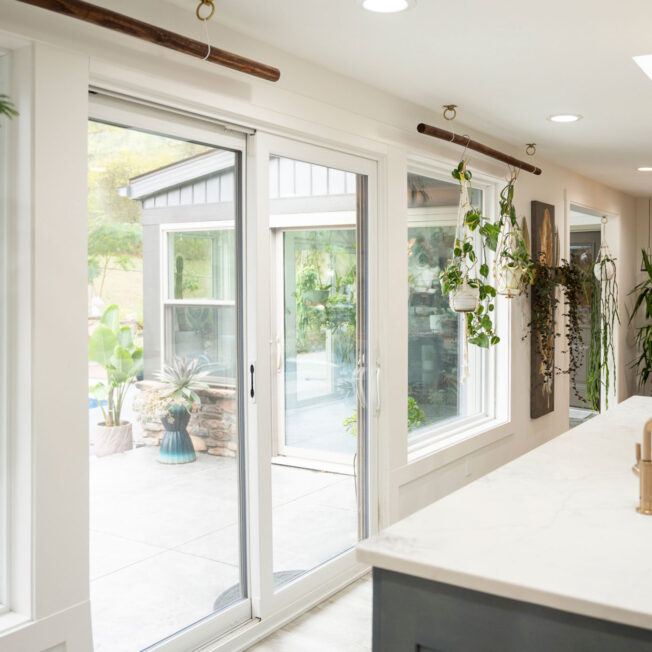 {Interior view of an Endure™ Sliding Patio Door in White Woodgrain Laminate looking out at a pool from the kitchen}