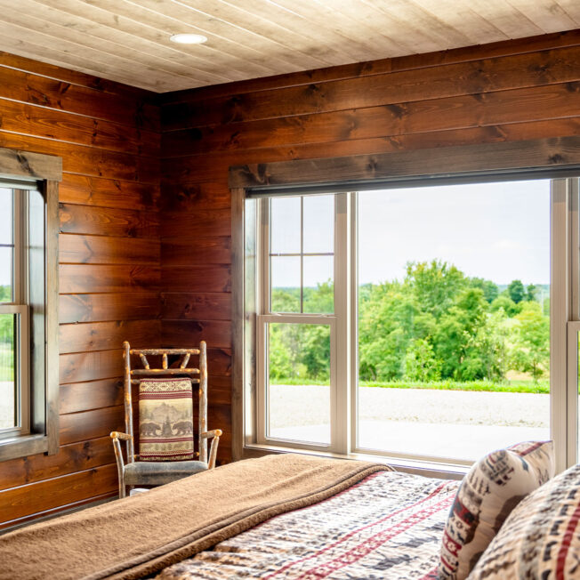 {Interior view of ProVia® Endure™ Double Hung and Picture Windows in Sandstone in a log home}