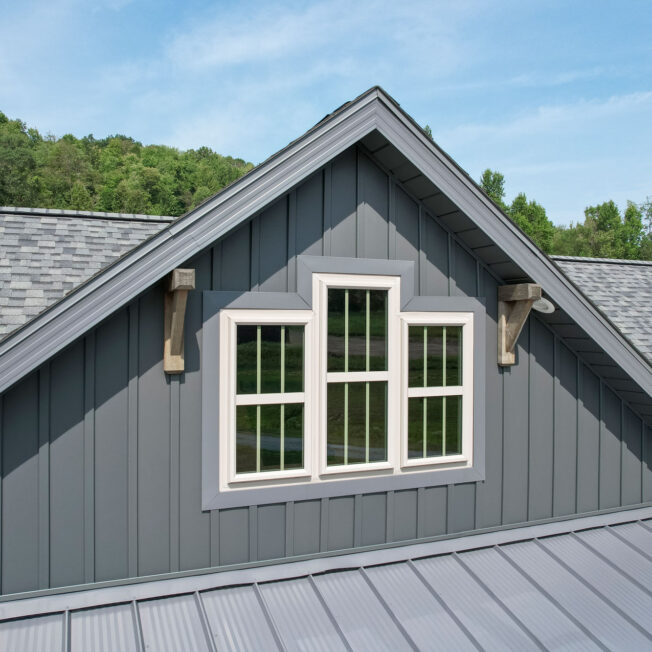 {Three Endure™ Double Hung Windows in Sandstone with Cottage Grids on a craftsman-style home exterior}