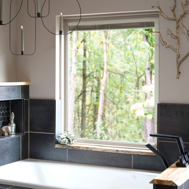 {Interior view of a ProVia® Endure™ Picture Window in White Woodgrain Laminate above a garden tub}