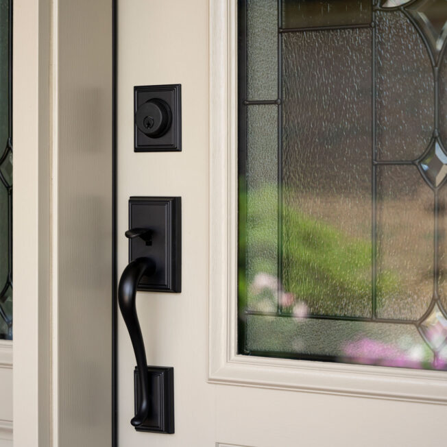 {Closeup of a ProVia® Signet® Mahogany 440-2P decorative front door in Sandstone with Esmond Decorative Glass}