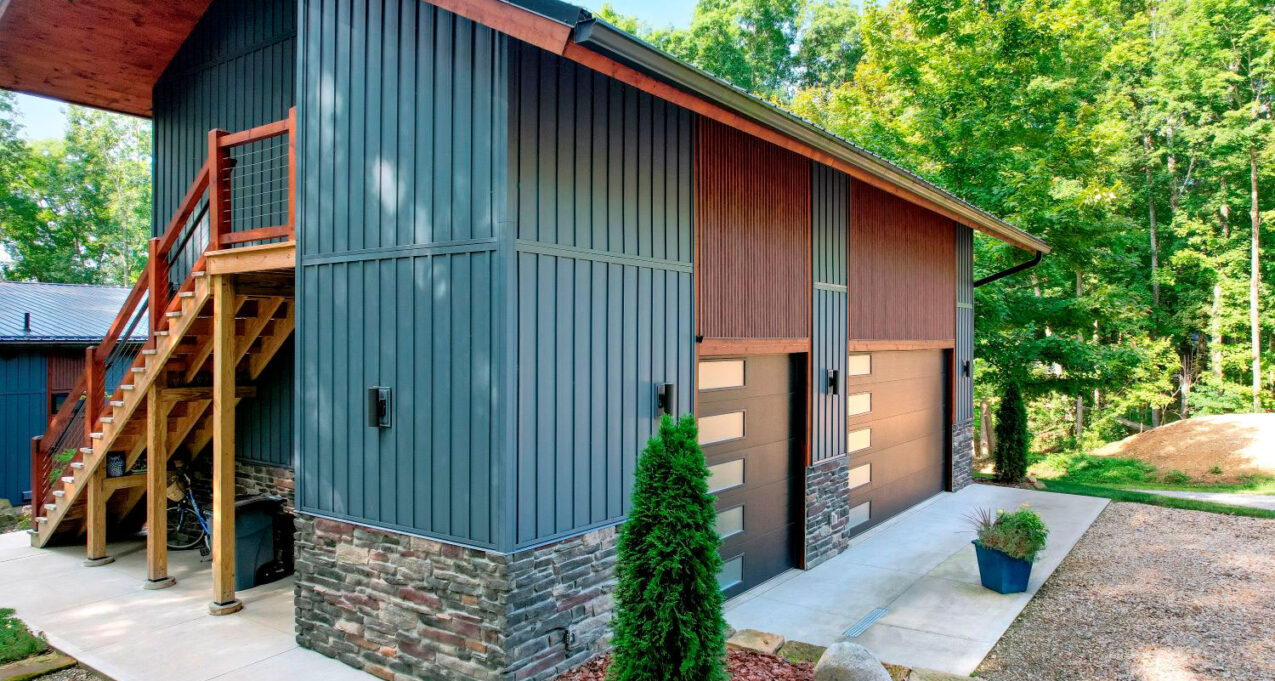 {ProVia CedarMAX® Board and Batten vertical siding in Sea Slate on a home combined with wood accents and stone.}