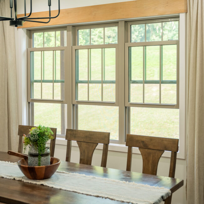 {Interior view of a dining room with ProVia® Endure™ Double Hung Mulled Windows in Sandstone}