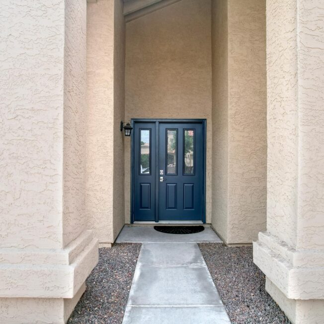 Exterior view of a ProVia® Legacy™ Smooth Steel 230 Entry Door with 130 Sidelite in Enzian Blue on a Spanish home exterior style