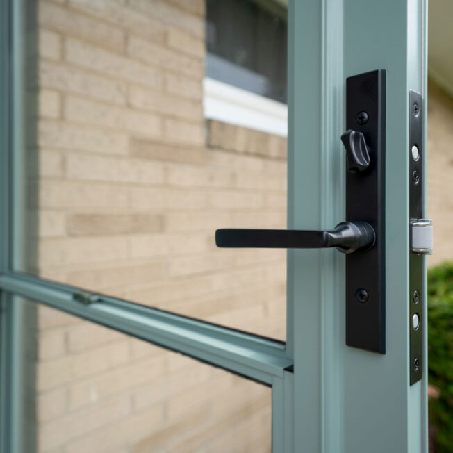 Closeup of Mortise Camden Storm Door Hardware in Black on a Eucalyptus green ProVia® storm door