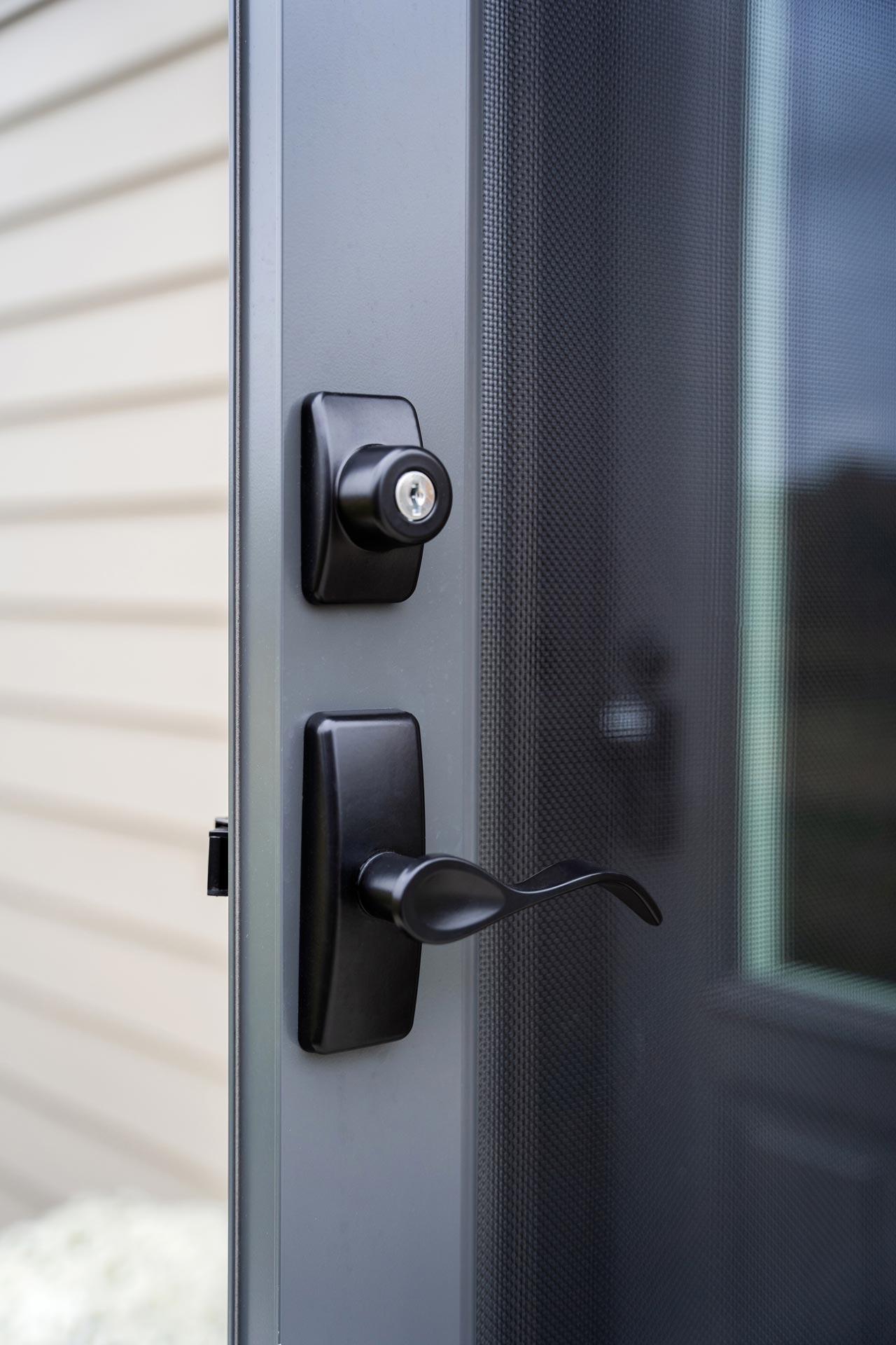 Contemporary Curve Storm Door Hardware in Black on a dark gray Nightfall ProVia® storm door
