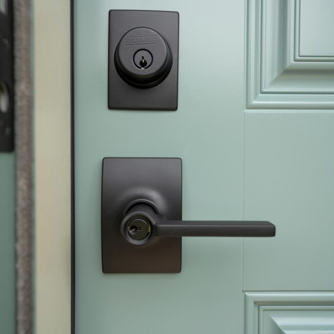 Schlage® Classic Latitude Lever in Satin Nickel with Century Trim in Black on a ProVia® Eucalyptus green entry door