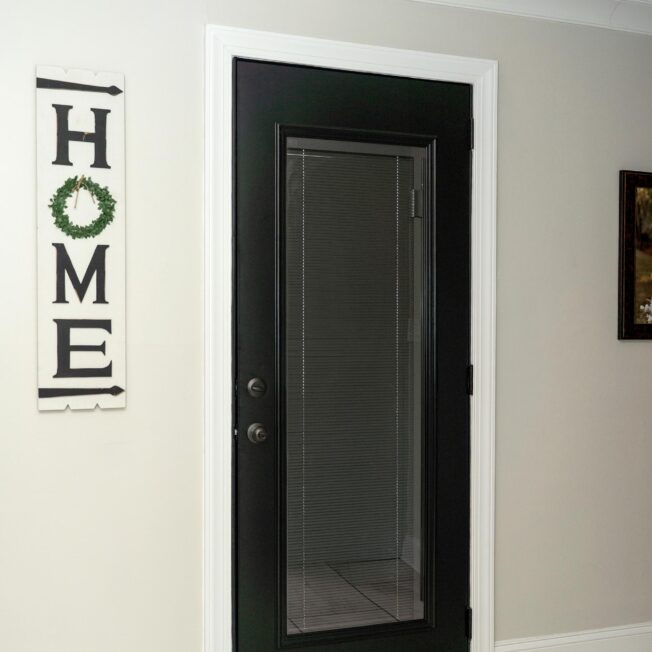 Exterior view of a Legacy™ smooth steel entry door in Coal Black with Black Internal Blinds, style 460