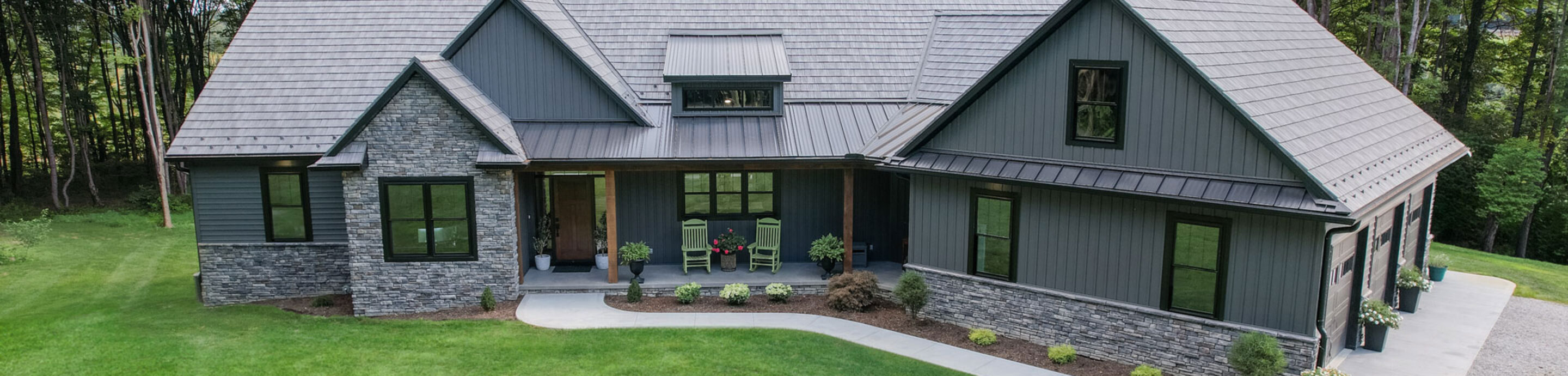 Ranch home exterior showcasing a ProVia® entry doors, windows, siding, stone, and roofing