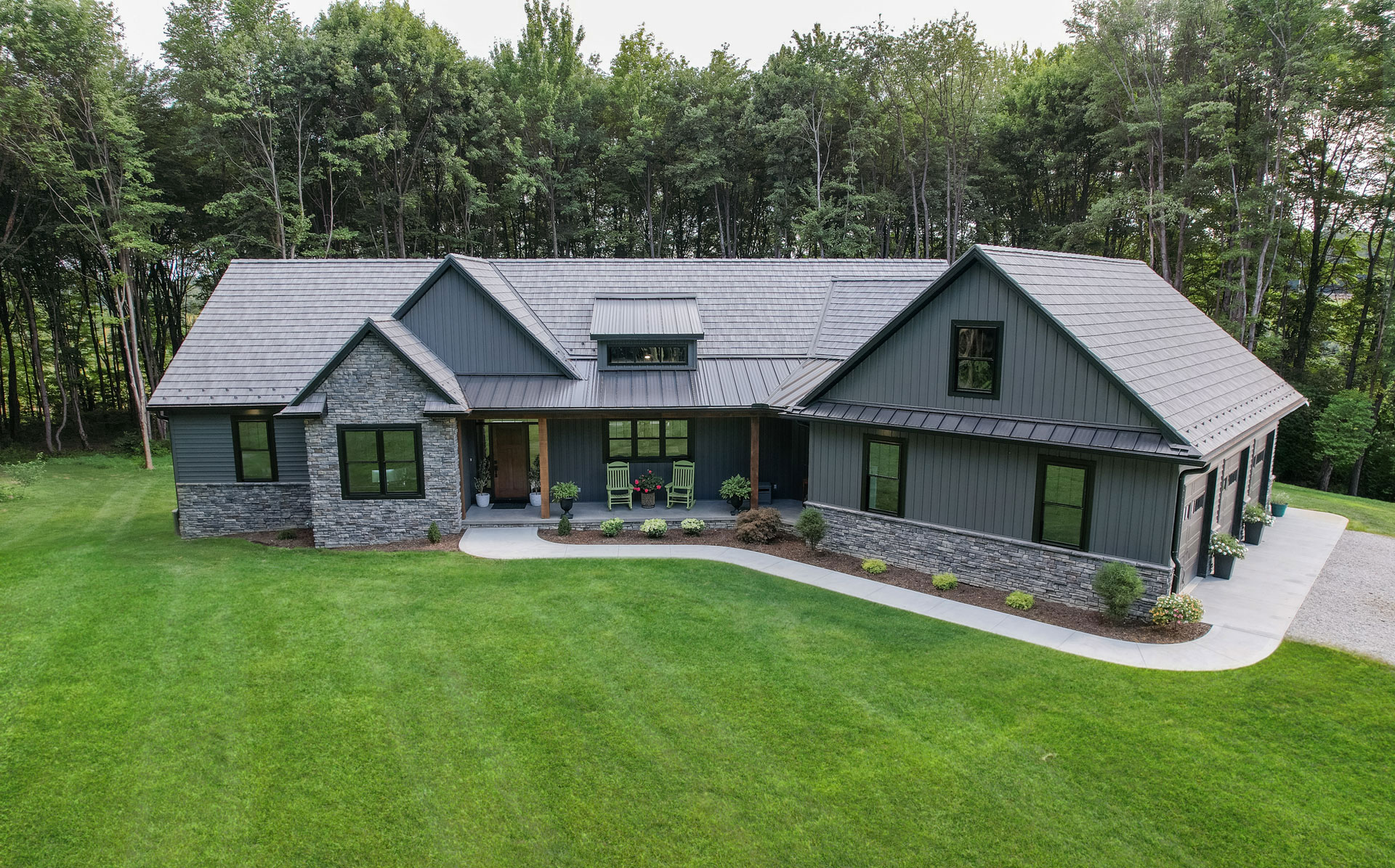 Ranch home exterior showcasing a ProVia® entry doors, windows, siding, stone, and roofing