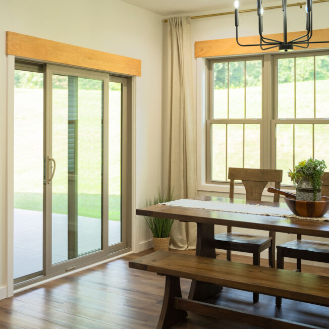 Interior dining room view of a ProVia® Endure™ 2-Lite Sliding Patio Door and Double Hung Windows in Sandstone