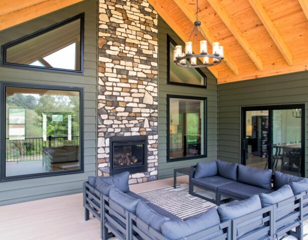 ProVia® Endure™ Picture Windows, Shaped Windows, and 2-Lite sliding patio door in Textured Matte Coal Black with CedarMAX® insulated vinyl siding in the color Pine