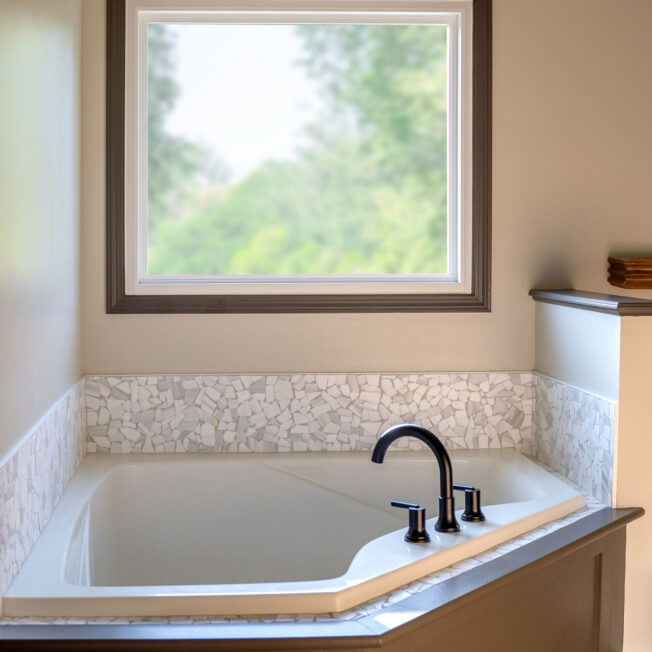 Interior view of a ProVia® Endure™ Picture Window in White in a bathroom above a garden tub