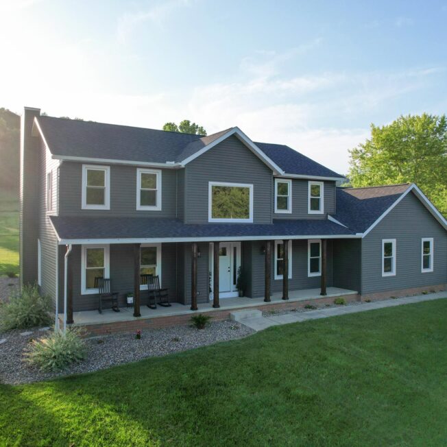 Two-story home featuring ProVia® HeartTech® Double 4" Dutch Lap Vinyl Siding in Timberline