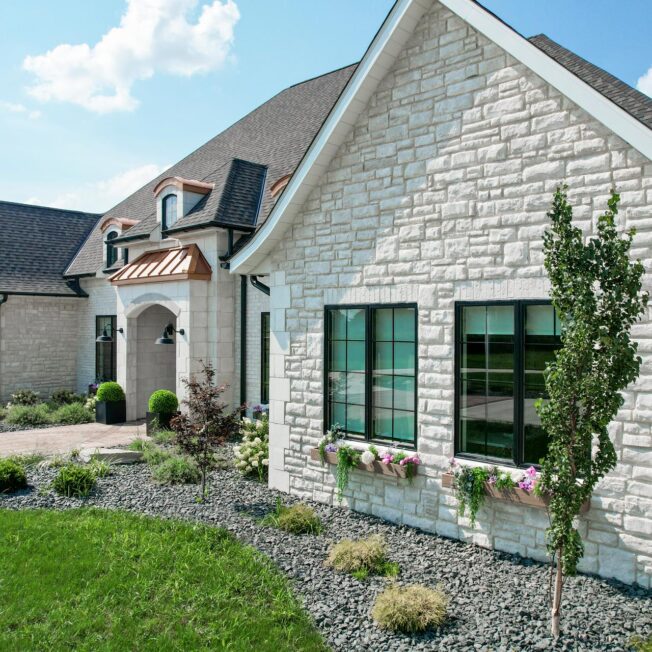Exterior view of a home featuring ProVia® Limestone Manufactured Stone in the color Vail