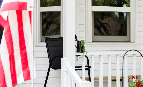 Exterior view of a white home with a porch and ProVia® Endure™ Single Hung Windows in White