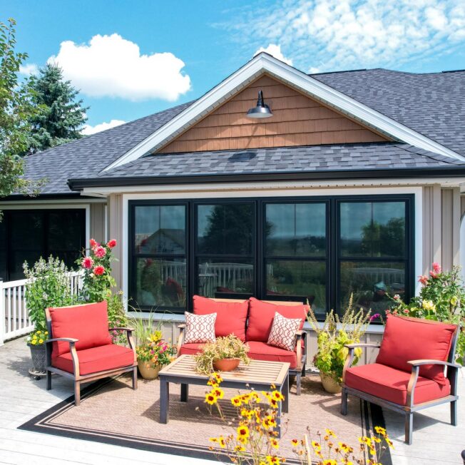 Exterior view of a home with a deck featuring ProVia® Endure™ Double Hung Mulled Windows in Textured Matte Coal Black