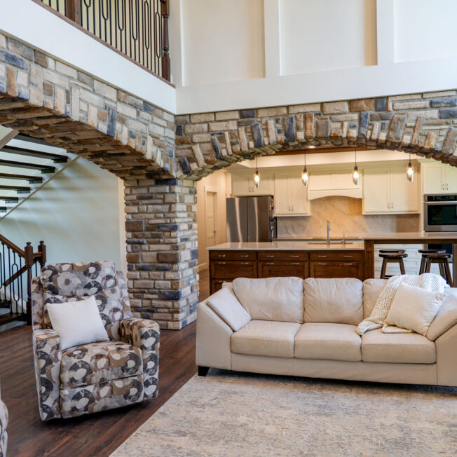 Interior view of a family room with arched columns covered with ProVia® Dry Stack Lakepointe Manufactured Stone for interior accents