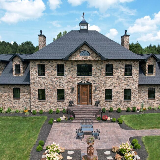 Exterior view of ProVia® Ridge Cut™ Yosemite Manufactured Stone on a large colonial style home