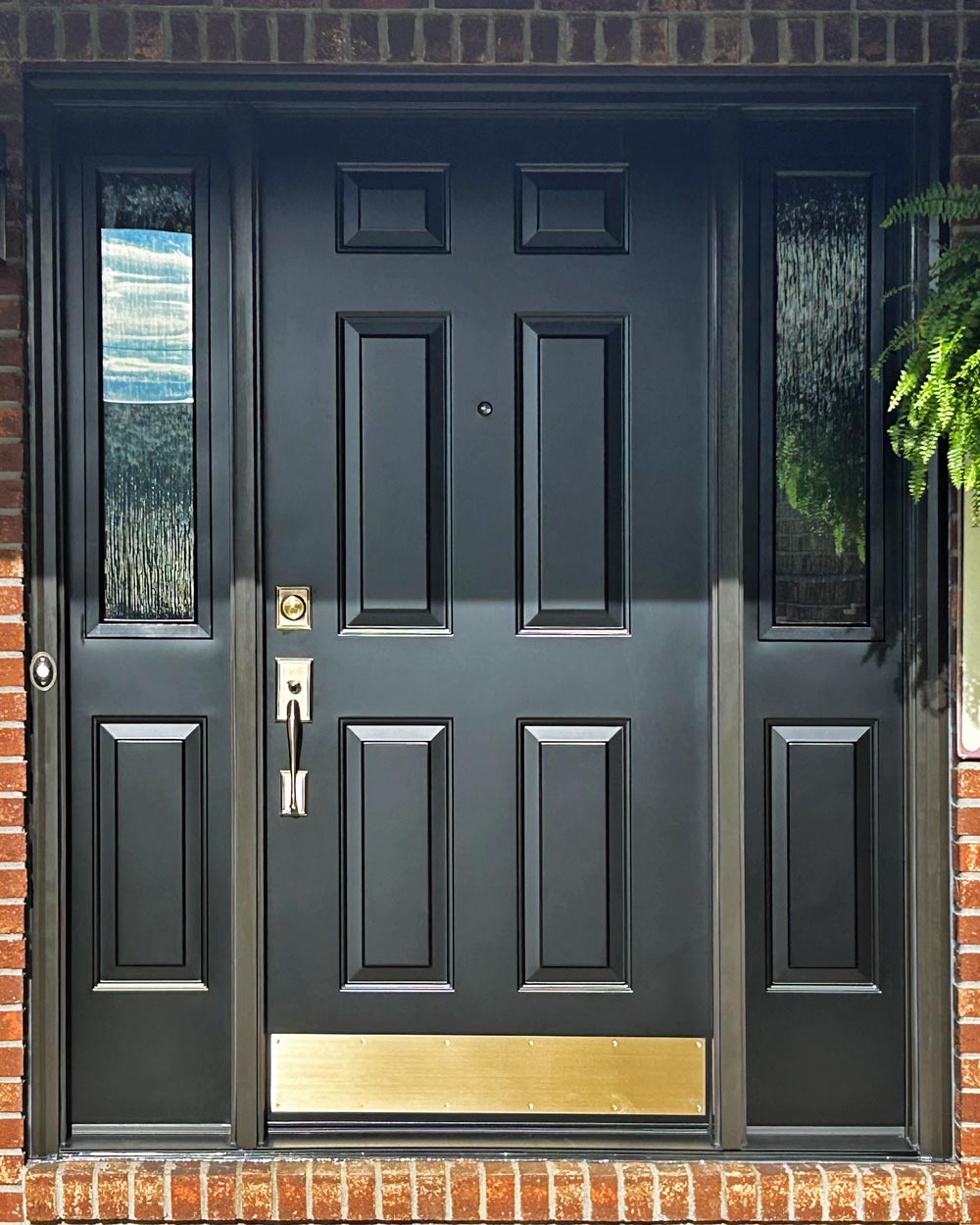 Closeup view of a ProVia® Legacy™ Smooth 006 Entry Door and 130 Sidelites in Coal Black with Waterfall Privacy Glass