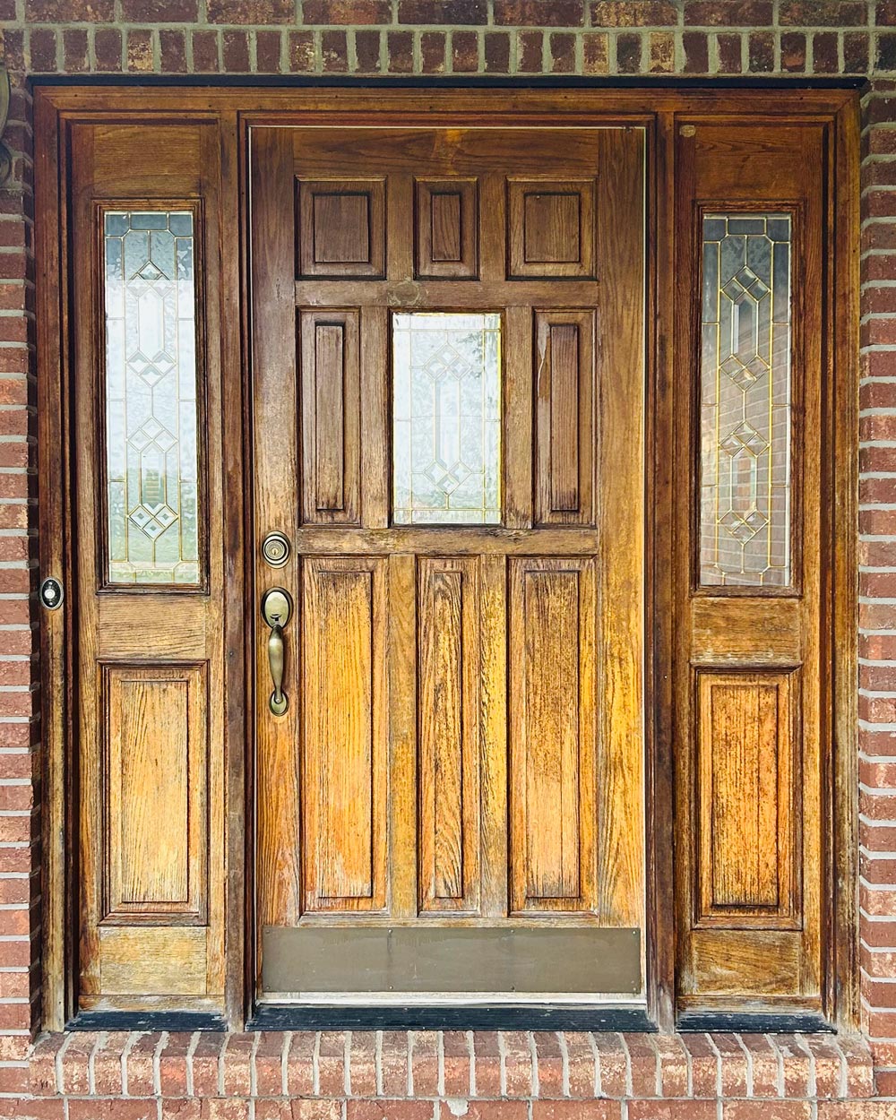 Exterior view of a weathered looking wood door before getting a new door